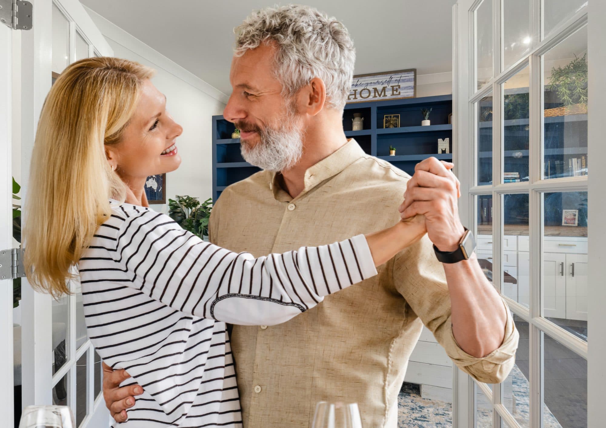 A couple dancing together in their kitchen at home